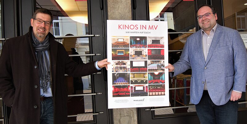 Geschäftsführer Volker Kufahl und Projektleiter "Strategische Kinoplanung", Fabian Liebenow, von der FILMLAND MV gGmbH präsentieren das Plakat.